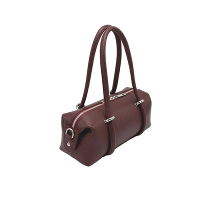 Side view of a burgundy east west handbag on a white background