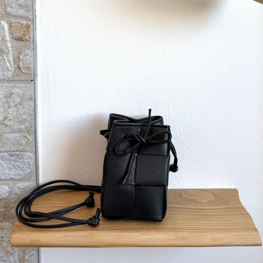 Emi handmade black leather woven crossbody bag with drawstring closure and long strap.
