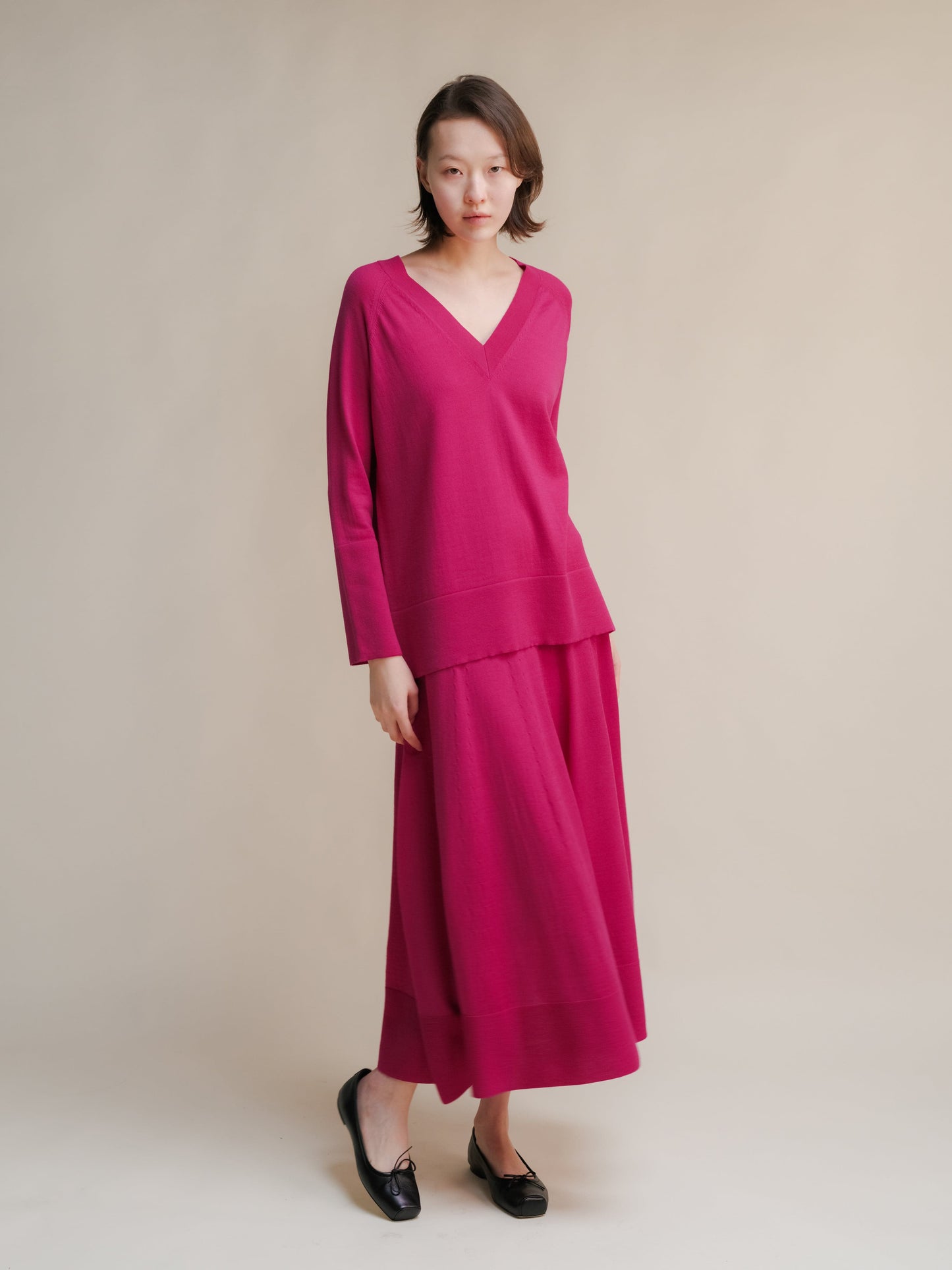 Full-length magenta merino wool A-line skirt worn with a matching knit top on a model