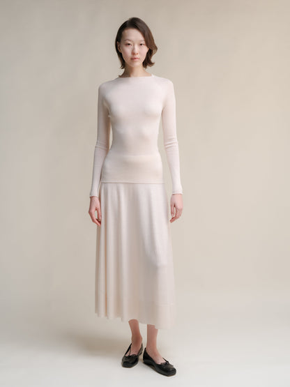 Cream Extra Fine Merino Wool 3D-Knit A-line skirt paired with a matching knit turtleneck sweater.