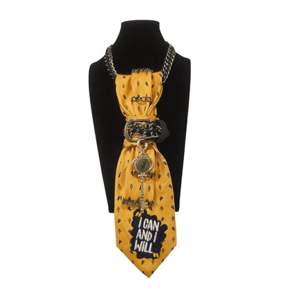 I can and I will 4-in-1 Jeweled Tie displayed on a black bust with yellow patterned fabric and chain accents