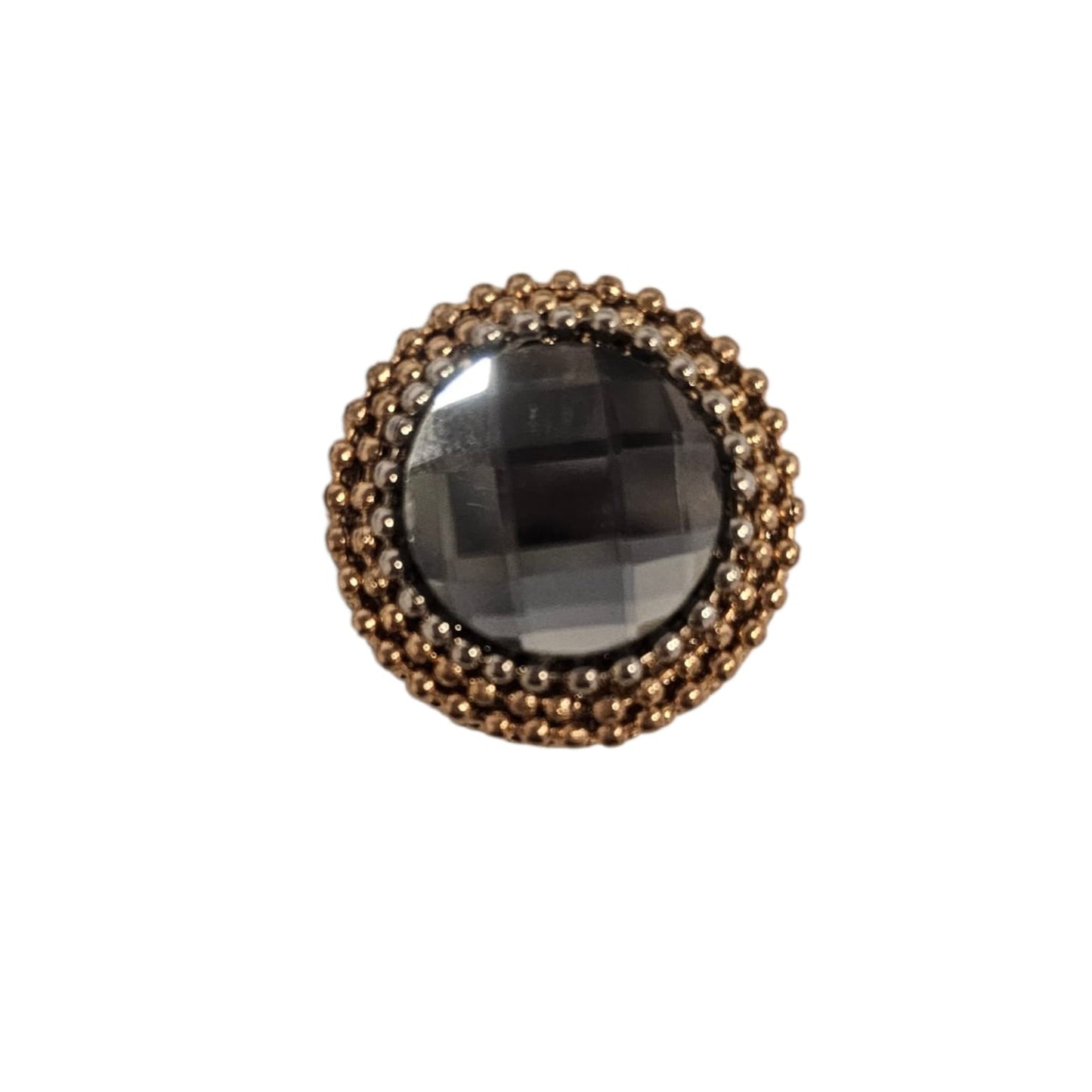 Circular black faceted gem surrounded by two concentric rings of gold beads