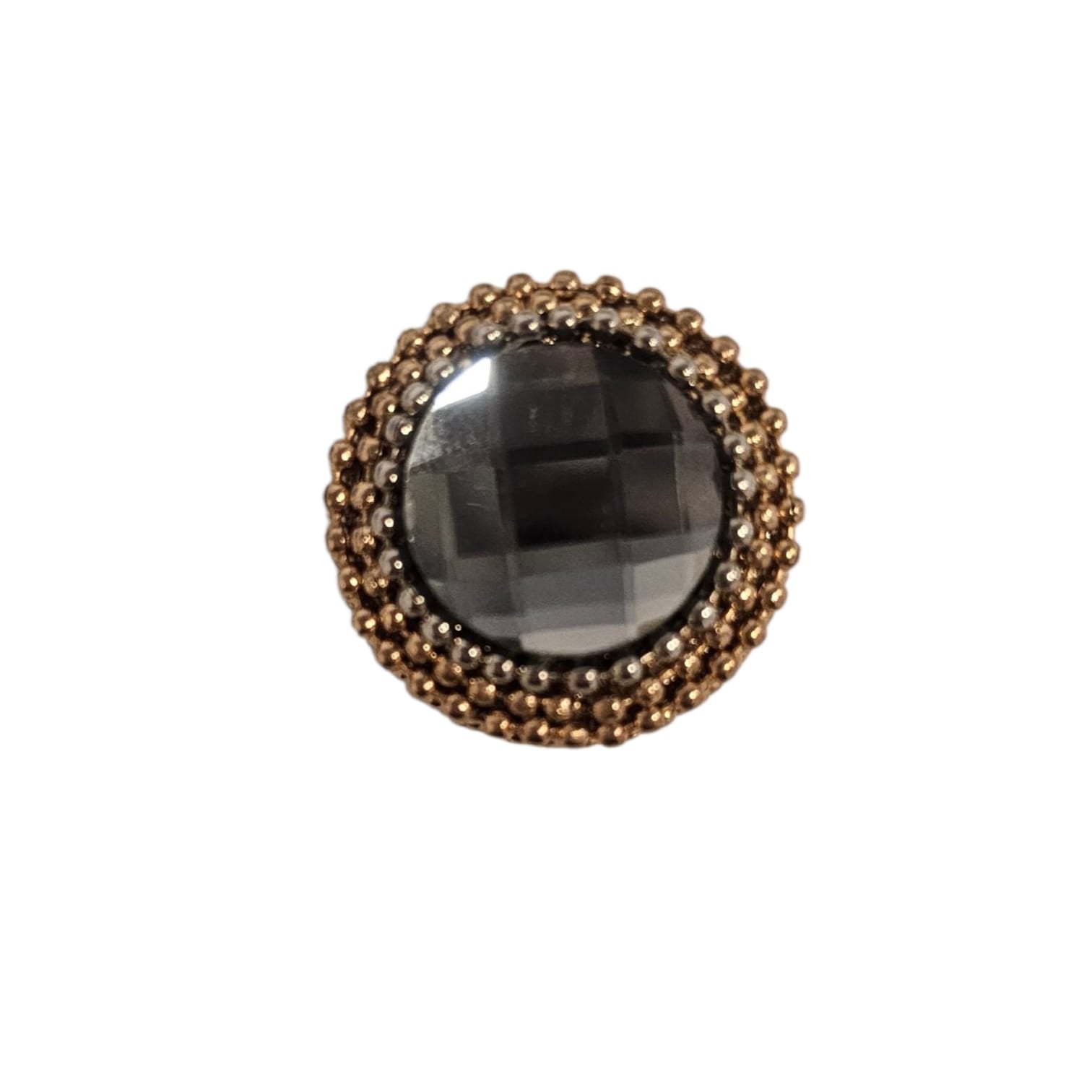 Circular black faceted gem surrounded by two concentric rings of gold beads