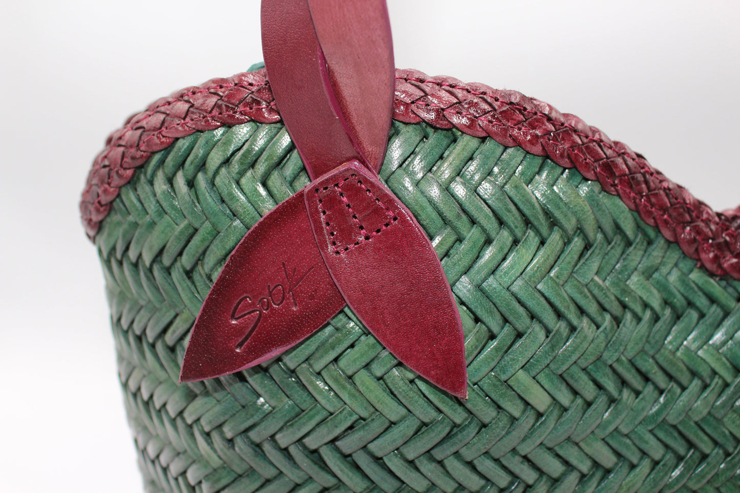 Léafa - Handwoven Leather Shoulder Bag | Burgundy & Green close-up of woven leather texture with burgundy trim and green leather body detail.