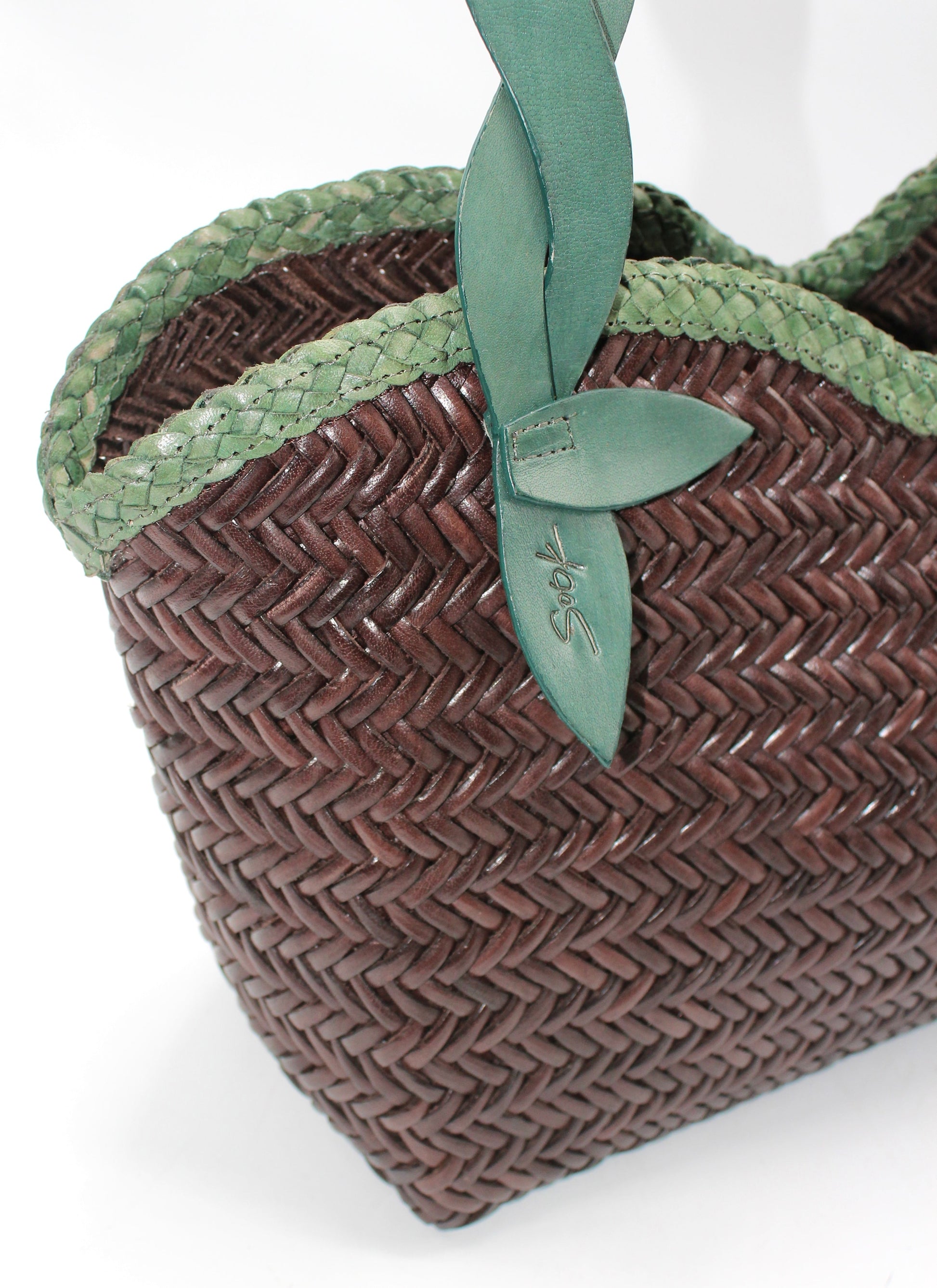 Léafa - Handwoven Leather Shoulder Bag | Green & Coffee featuring tightly woven brown leather with braided green leather trim and leaf-shaped strap detail