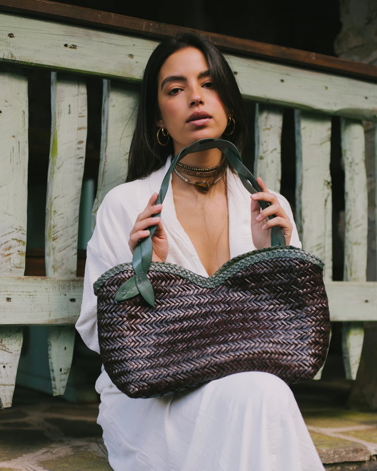 Léafa - Handwoven Leather Shoulder Bag | Green & Coffee showing woven leather texture with green leather handles held by model in white outfit.