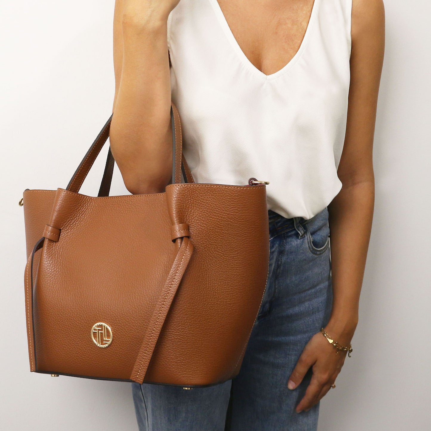 Legame - Italian leather shopping bag - Large size | TL142481 in brown pebbled leather with dual top handles and gold-tone circular hardware held against a white top.