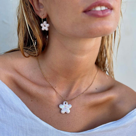 Pearl-pink flower ceramic pendant on a delicate gold chain worn at the neck