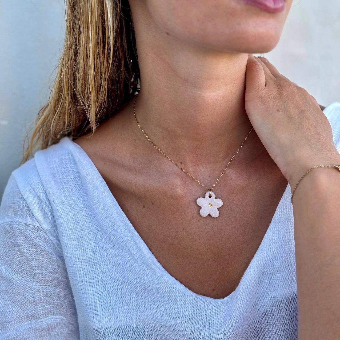 Margherita pink floral ceramic necklace with a delicate gold chain resting at the collarbone.