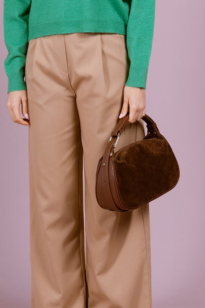 Person holding Montepulciano – Italian Suede Leather Hobo Bag in dark brown with smooth leather side panels and short handle strap.