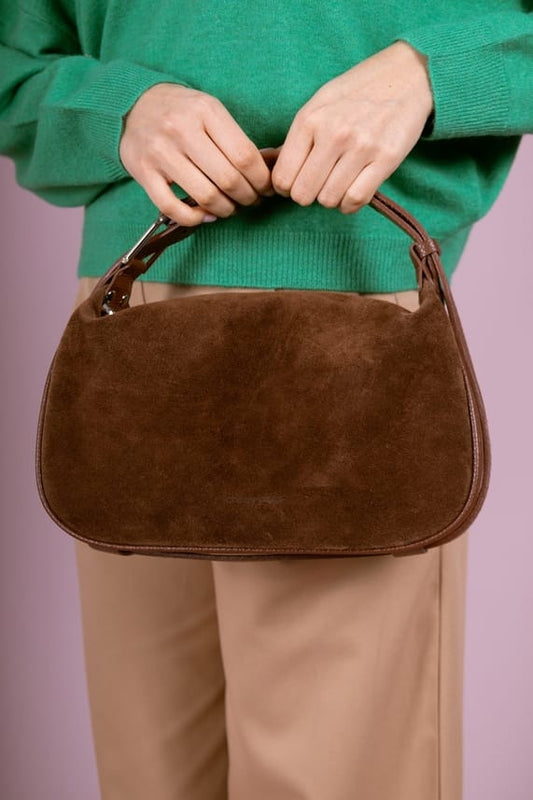 Hands holding Montepulciano – Italian Suede Leather Hobo Bag in rich brown suede with smooth leather trim and compact design.