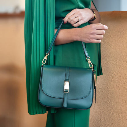 Nausica teal blue leather shoulder bag with gold hardware and adjustable strap worn on the model’s shoulder