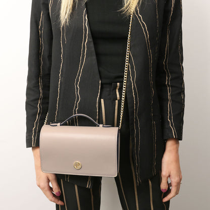 Opera - Leather clutch with chain strap | TL142505 in taupe smooth leather with gold-tone chain and top handle, worn crossbody on striped outfit