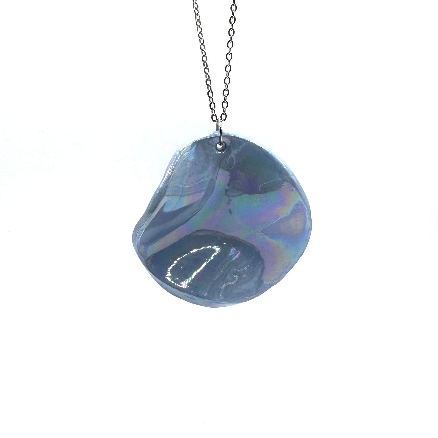 Iridescent blue ceramic pendant necklace on a silver chain against a white background