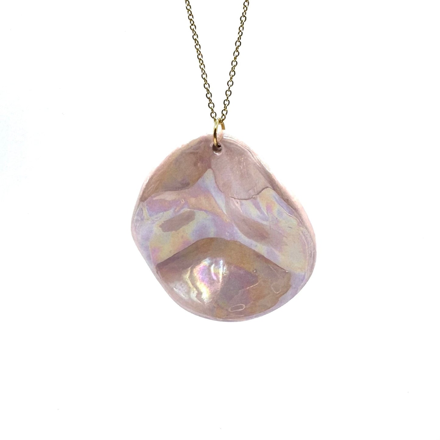 Pearl-pink ceramic pendant necklace on a gold chain against a white background