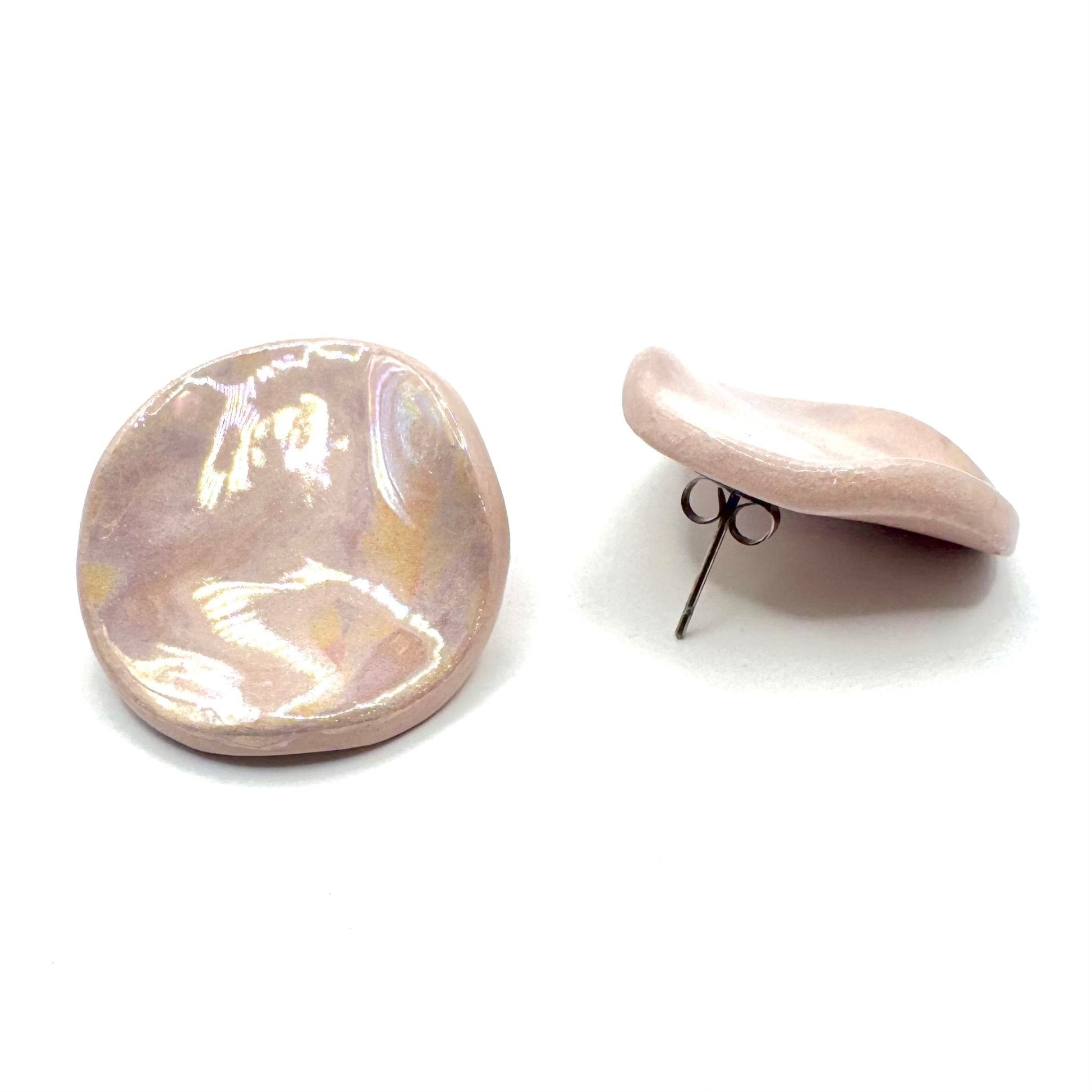 Round handcrafted pearl pink ceramic stud earring on a white background