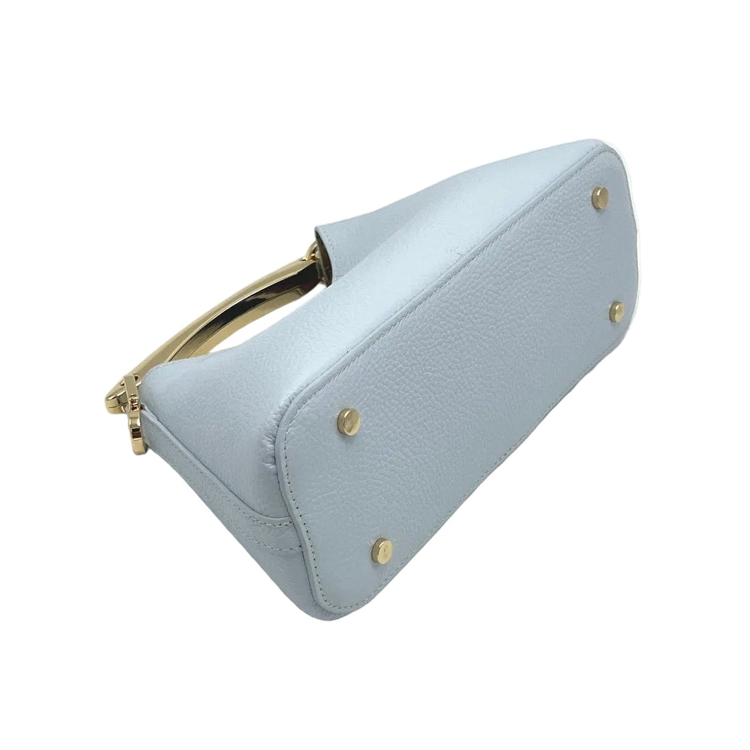 Light blue handbag with gold accents on a white background