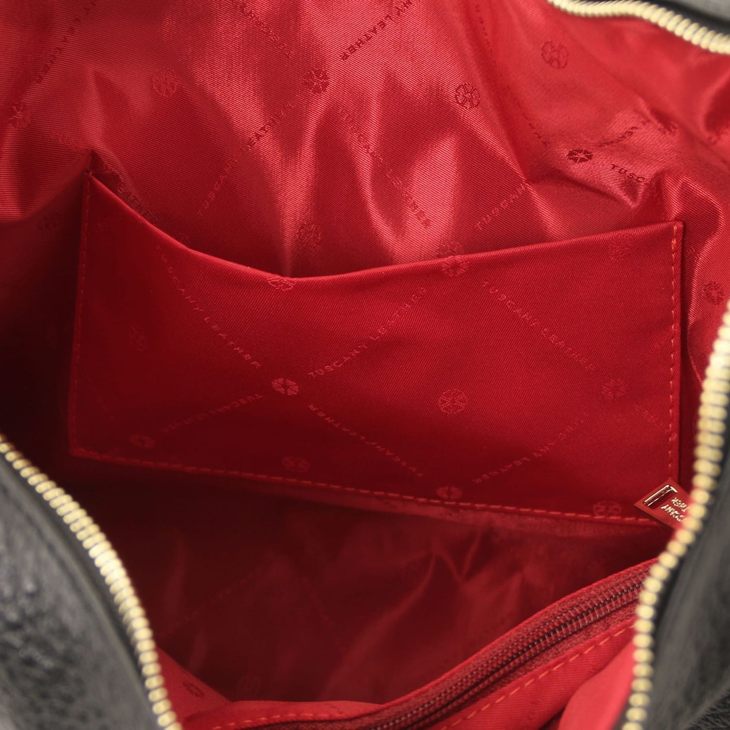 Red interior lining of Plenia Italian leather shopping bag with a pocket and repeating logo pattern