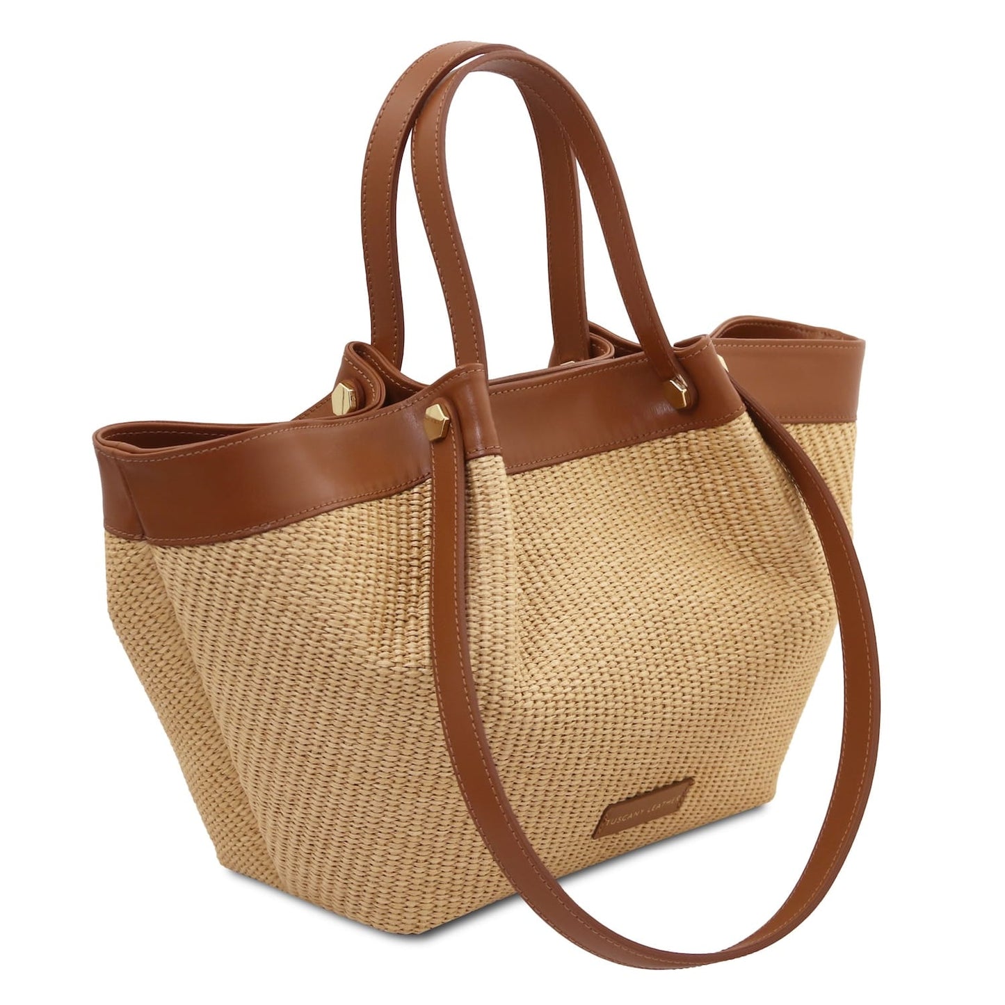 Side angle view of raffia tote with brown leather trim and long shoulder strap