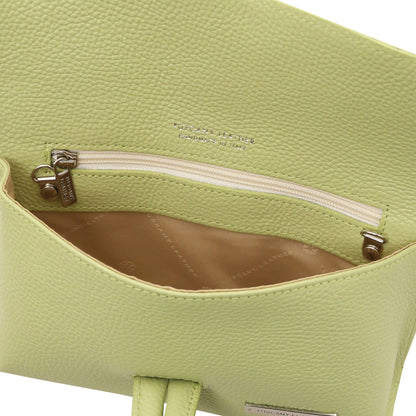 Close-up of lime green textured leather bag interior showing a zip pocket and tan lining