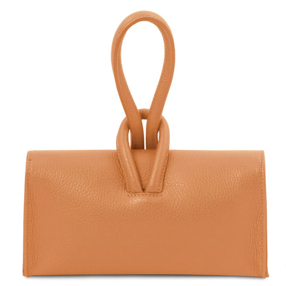 Close up of tan leather foldover clutch highlighting the double loop top handle and wrapped strap
