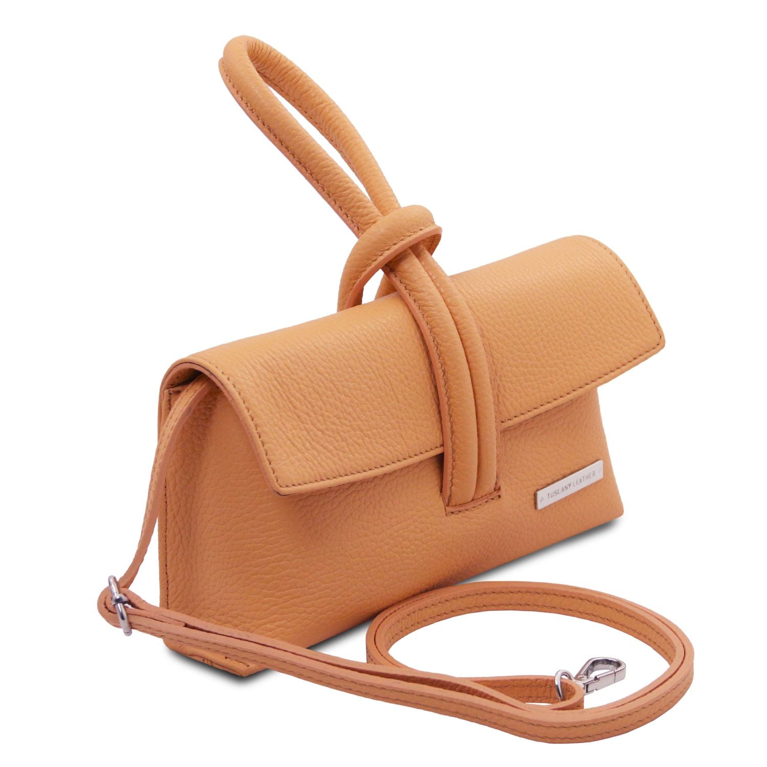 Three quarter view of tan leather foldover clutch with attached shoulder strap and wraparound loop