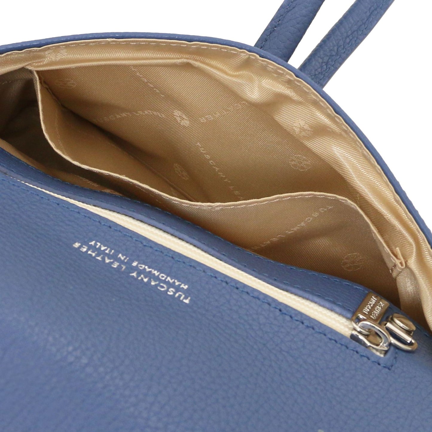 Open blue leather clutch with beige patterned lining and internal pocket.