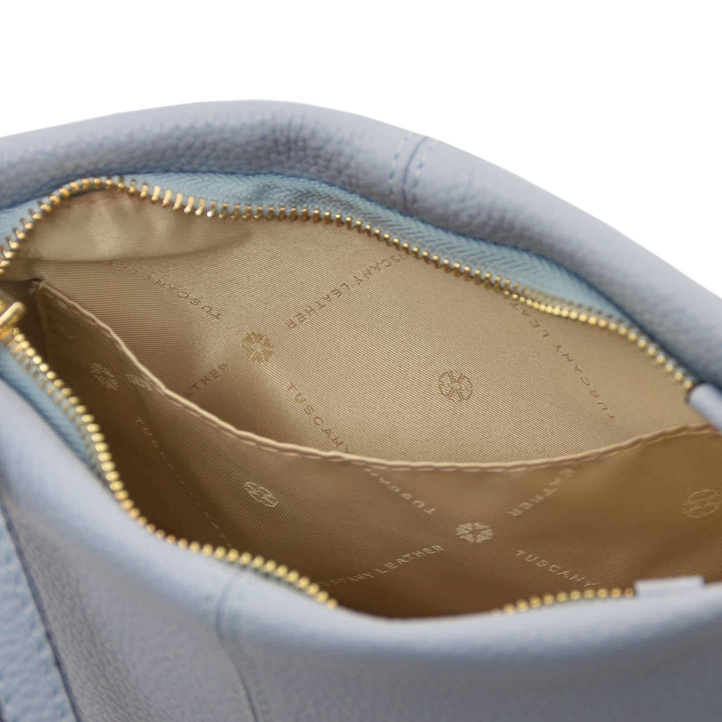 Open view of soft pebbled light blue leather shoulder bag showcasing beige interior lining with logo print and open pocket detail.