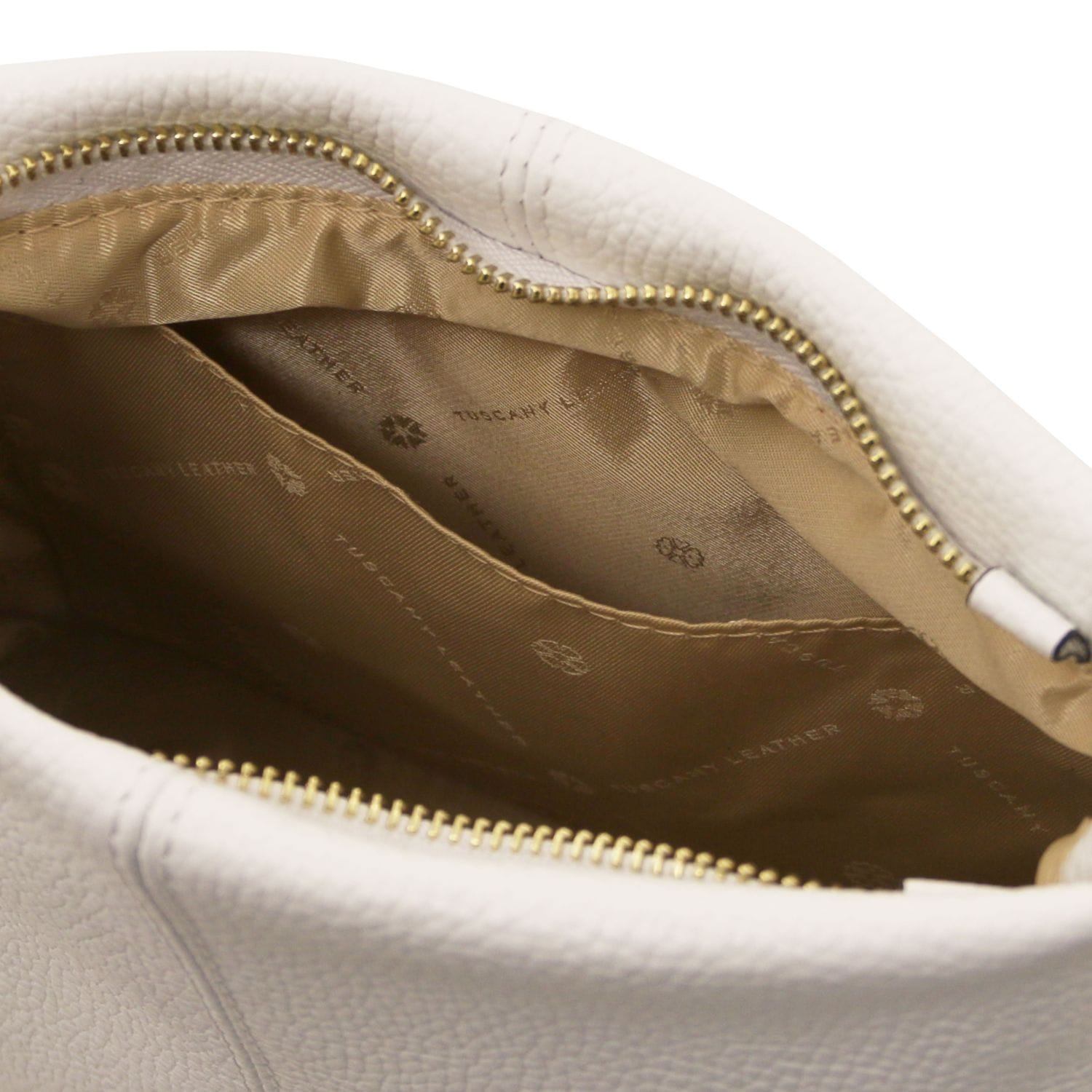 Close-up of soft white leather bag interior with beige fabric lining and gold zipper detailing.