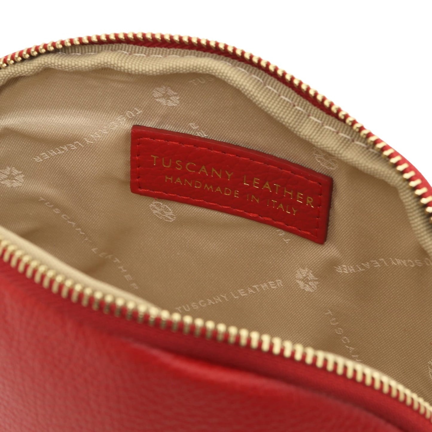 Red Vera leather toiletry case opened to reveal beige lining and a handmade in Italy label.