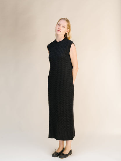 Black sleeveless cable knit midi dress crafted from a Wool & Cashmere Mix Sleeveless Cable Knit Dress with a high neckline.