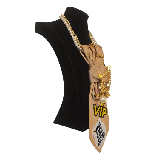 Beige You Are Amazing 4-in-1 Jeweled Tie shown in side view with gold chains patches on a display bust
